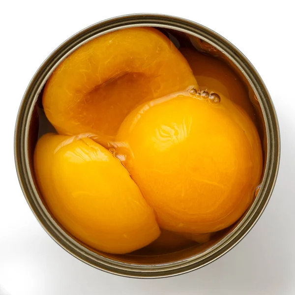Відкрита банка половинок персика в сиропі зверху. Ізольовані на білому . — стокове фото