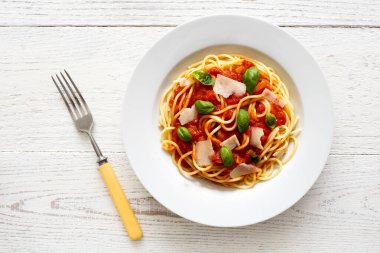 Domates soslu spagetti, taze fesleğen ve peynir. Çatalla.