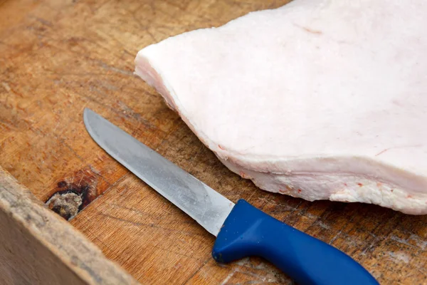 Trozo de manteca de cerdo con cuchillo sobre tabla de madera . —  Fotos de Stock