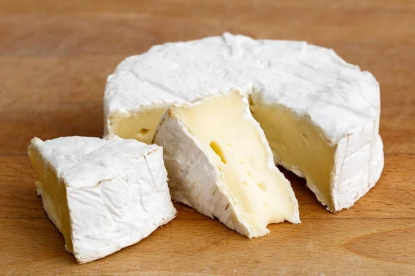 Queijo de molde branco com fatias cortadas isoladas em tábua de madeira . — Fotografia de Stock