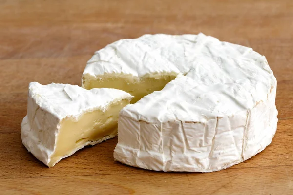Fehér penész sajt vágott szelet elszigetelt fa fórumon. — Stock Fotó