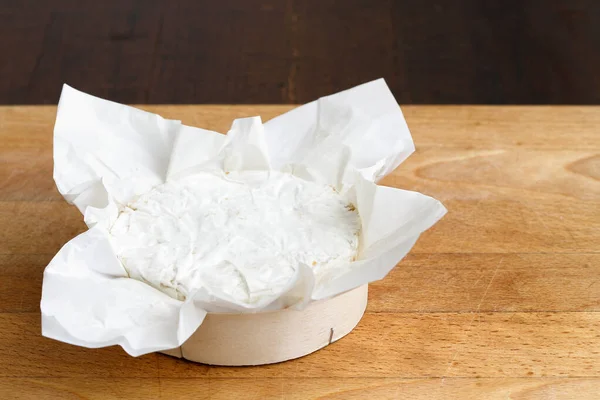 Ganz weißer Schimmelkäse in Verpackung auf Holzkarton. — Stockfoto