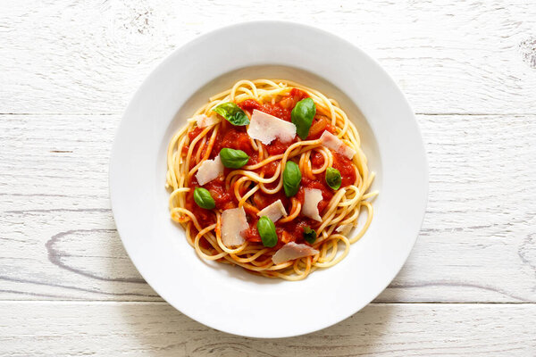 Spaghetti with tomato sauce, fresh basil and cheese. On white wo