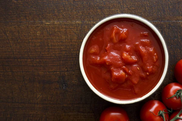 Tazón de cerámica marrón de tomates en conserva picados . — Foto de Stock