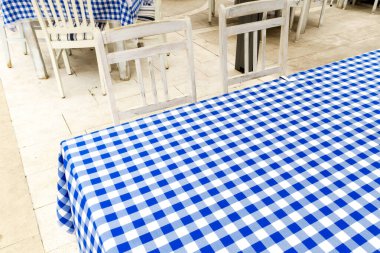 Boş masa mavi ve beyaz kareli masa örtüsüyle kaplı.