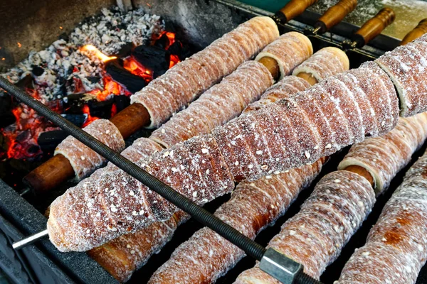 Cottura di pasticceria trdelnik all'aperto sul fuoco a legna . — Foto Stock