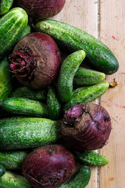 Vers geoogste augurken komkommers en bieten op licht hout — Stockfoto