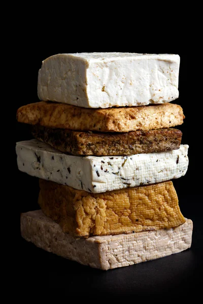 Pilha de blocos de tofu misturados isolados em preto . — Fotografia de Stock
