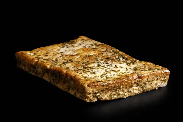 Single block of marinated tofu with herbs  isolated on black. — Stock Photo, Image