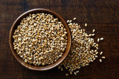 Koyu kahverengi kasede izole edilmiş buğday taneleri. 