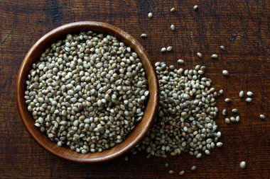 Koyu kahverengi ahşap kaptaki kenevir tohumları 