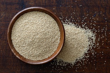 Amaranth tohumları koyu kahverengi ahşap kasede izole edilmiş.