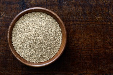 Amaranth tohumları koyu kahverengi ahşap kasede izole edilmiş.