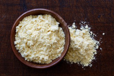 Koyu kahverengi ahşap kasede izole edilmiş mısır unu. 