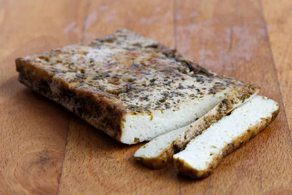 Bir kalıp terbiye edilmiş tofu, otlar ve iki dilim soya peyniri. — Stok fotoğraf