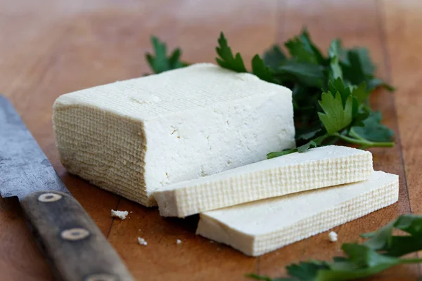 Bloc de tofu blanc avec deux tranches de tofu, couteau rustique et frais — Photo