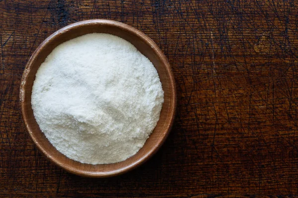 Farinha de arroz branco em tigela de madeira escura isolada em madeira marrom escura — Fotografia de Stock