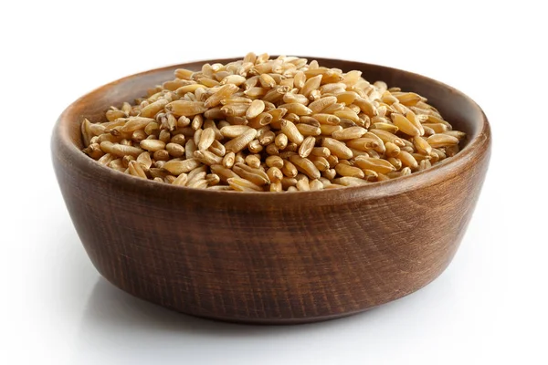 Kamut wheat kernels in dark wooden bowl isolated on white. — Stock Photo, Image