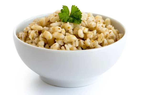 Cooked pearl barley with green parsley in white ceramic bowl iso — Stock Photo, Image