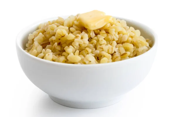 Cooked bulgur wheat with butter in white ceramic bowl isolated o — Stock Photo, Image