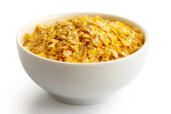 Dry flaked corn in white ceramic bowl isolated on white. — Stock Photo, Image