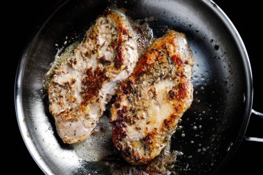 Yukarıdan metal bir tavada iki tavada kızarmış ördek göğsü fileto..