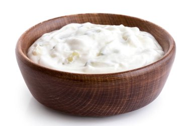Tzatziki in brown rustic wood bowl isolated on white.