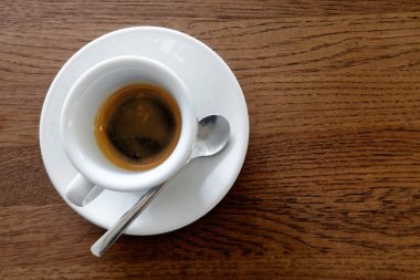 Klasik italyan espresso beyaz bardakta, kahverengi W üzerine izole edilmiş.