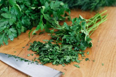 Yeni doğranmış maydanoz sürüsü tahta üzerinde. 