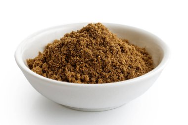 Zemin kişniş tohumları beyaz seramik kasede izole edilmiş..