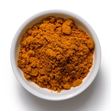 Beyaz seramik kasedeki köri tozu beyazdan izole edilmiş..