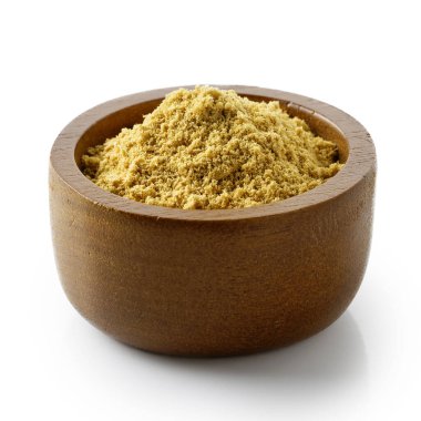 Koyu ahşap kasedeki kuru zencefil beyaza izole edilmiş..