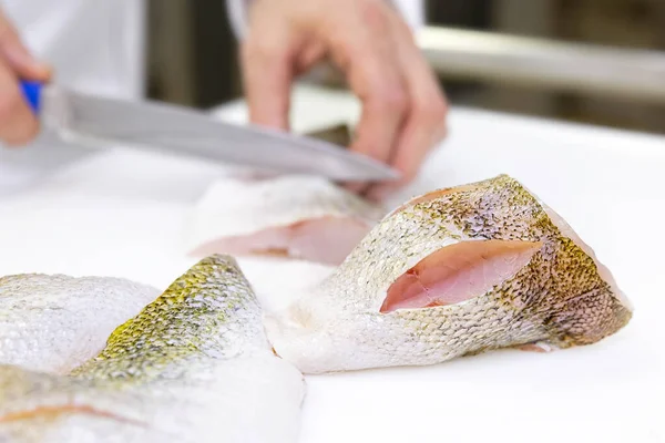 Um chef a marcar filetes de peixe com uma faca. Helicóptero branco — Fotografia de Stock
