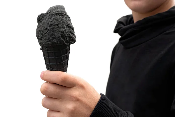 Um menino segurando sorvete preto em cone de bolacha preta. Branco backgro — Fotografia de Stock