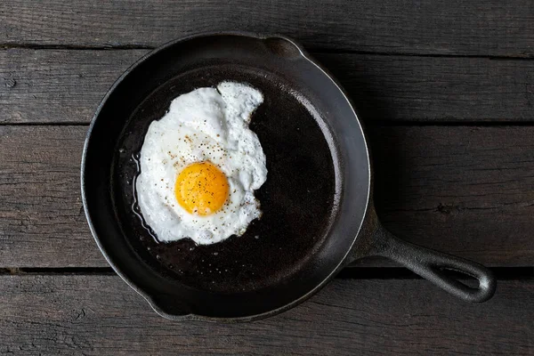 Único ovo frito em frigideira de ferro fundido polvilhado com terra b — Fotografia de Stock