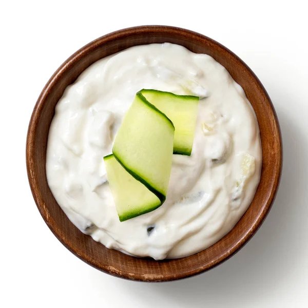 Tzatziki en tazón de madera rústico marrón con rebanada de pepino aislado —  Fotos de Stock