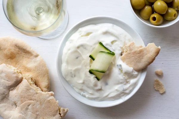 Tzatziki dans un bol en céramique blanche avec une tranche de concombre et un morceau — Photo