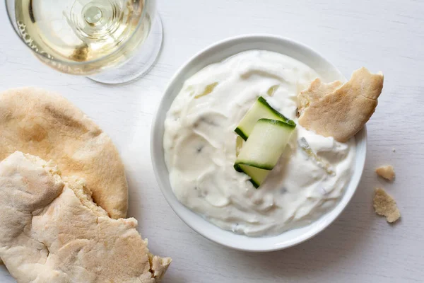 Tzatziki en tazón de cerámica blanca con una rebanada de pepino y una pieza —  Fotos de Stock