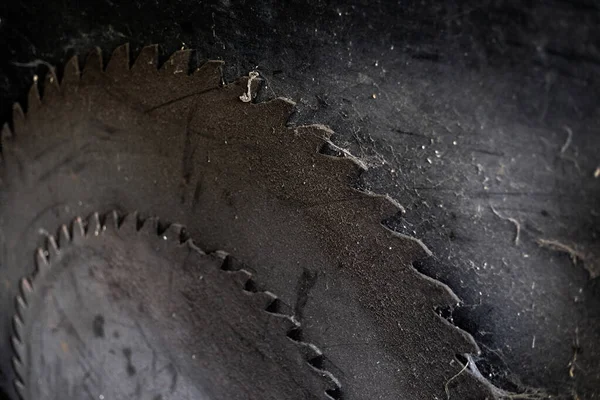 Background of dark metal saw blades of old circular saw with cob