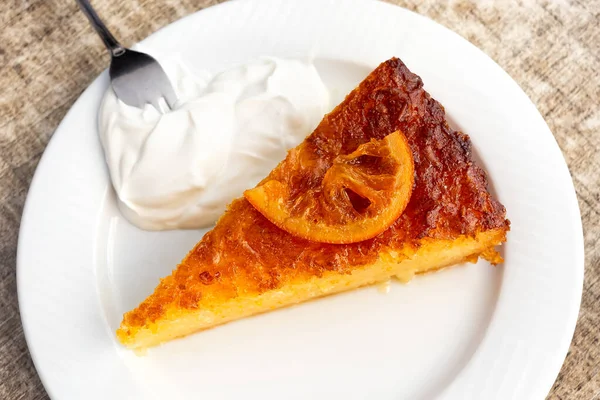 Kawałek tradycyjnego greckiego ciasta pomarańczowego z kwaśną śmietaną na białku — Zdjęcie stockowe