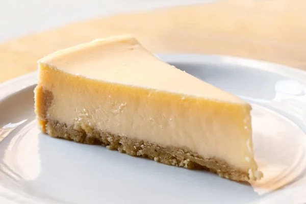 Eine Scheibe einfach gebackener Käsekuchen auf weißem Teller. — Stockfoto