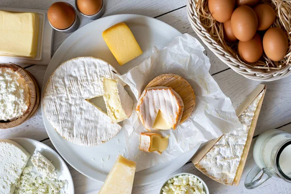 Queijo, leite, produtos lácteos e ovos em madeira branca rústica de — Fotografia de Stock