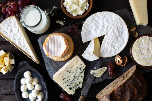 Peynir, süt ve süt ürünleri sade, siyah ahşap ve slate ba — Stok fotoğraf