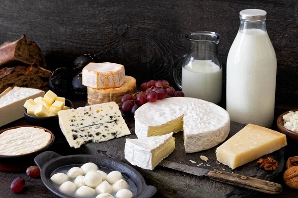 Cheese, milk and dairy products on rustic dark wood and slate ba — Stock Photo, Image