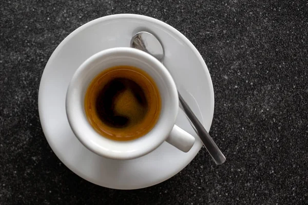 Liten italiensk espresso i vit keramisk kopp med sked isolerad — Stockfoto