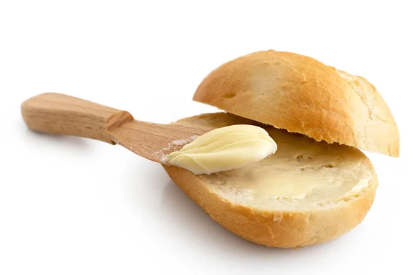Boter uitgespreid op een gesneden knapperig broodje met een houten mes iso — Stockfoto