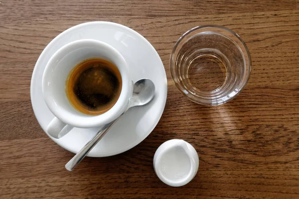 Beyaz bardakta klasik İtalyan espresso, süt sürahisi ve su. — Stok fotoğraf