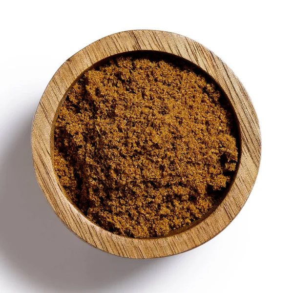 Ground cumin in dark wood bowl isolated on white from above. — Stock Photo, Image