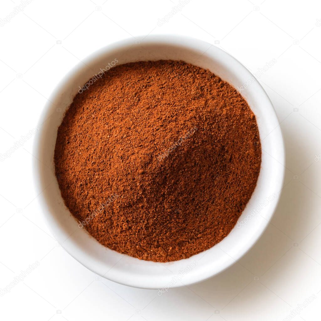 Finely ground cinnamon in white ceramic bowl isolated on white f