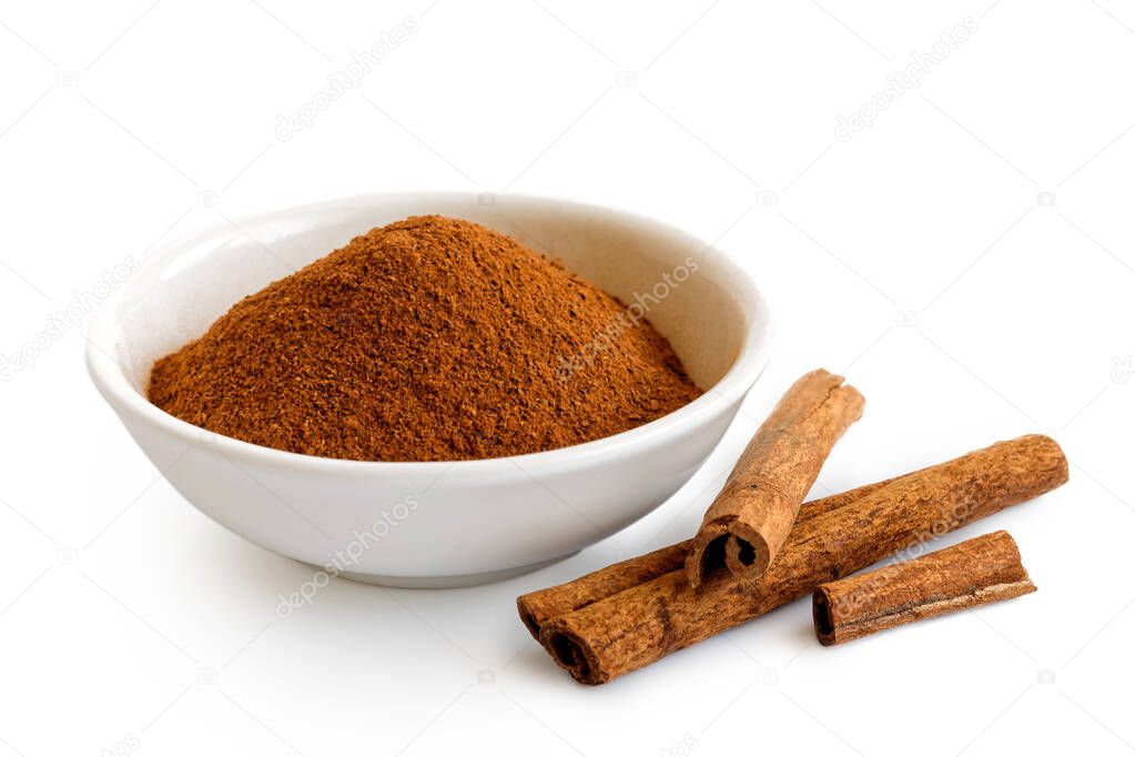 Finely ground cinnamon in white ceramic bowl isolated on white. 